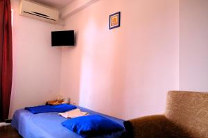 a room with a bed and a chair and a television at Vila Iulia in Eforie Nord