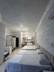 a bedroom with three beds and a kitchen at Family hotel Khomaldy in Kvariati