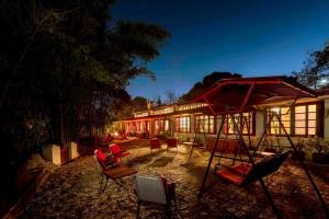 ein Haus mit roten Stühlen davor in der Unterkunft Oak Lodge 5BD Vintage Home in Bhowāli