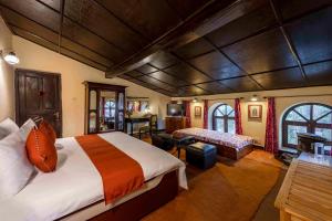 ein Schlafzimmer mit großem Bett und ein Wohnzimmer in der Unterkunft Oak Lodge 5BD Vintage Home in Bhowāli