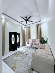 a living room with a couch and a ceiling fan at Aisyah Homestay in Kuala Ketil