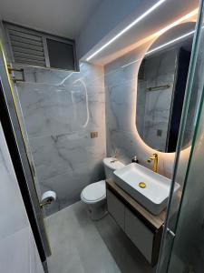 a bathroom with a sink and a toilet and a mirror at Espectacular Apartamento Ibagué in Ibagué