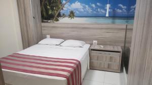 a bedroom with a bed with a view of the ocean at Gonzaga Praia Flat in Santos