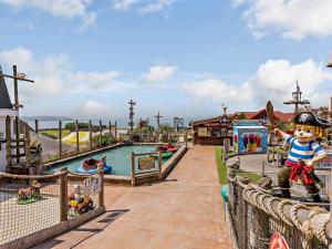 un enfant debout sur une clôture dans un parc aquatique dans l'établissement 2 Bed in Woolacombe 83425, à Woolacombe