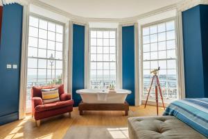 a bedroom with a tub and a chair and windows at Drakes Hotel in Brighton & Hove +37 photos