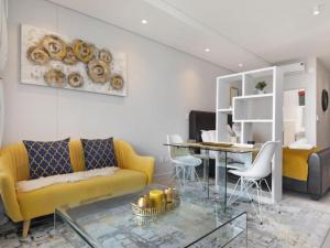 un soggiorno con divano giallo e tavolo in vetro di Zimbali Lakes Boulevard Suite, Euphoric Leisure a Ballito