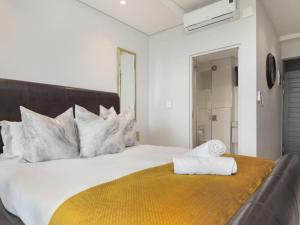 una camera da letto con un grande letto bianco con una coperta gialla di Zimbali Lakes Boulevard Suite, Euphoric Leisure a Ballito Altre 9 foto