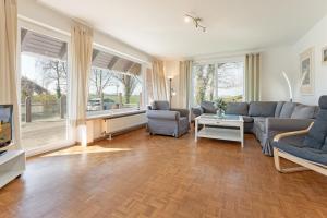 a living room with a couch and a tv at Op de Wei Sonnenterrasse in Fehmarn