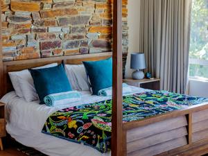 a bedroom with a bed with a brick wall at Sylvan Close 3, Umhlanga Rocks by Euphoric Leisure in Durban