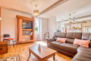 ein Wohnzimmer mit Couch und Tisch in der Unterkunft Gite Le Poirier Perigord Dordogne in Allemans