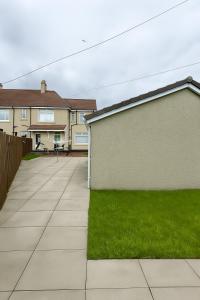 a house with a lawn next to a building at Register House Family or Contractor 4bed with Garden Driveway in Bellshill