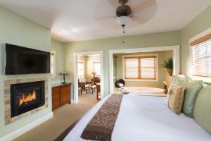 a bedroom with a bed and a fireplace and a tub at 1906 Lodge in San Diego