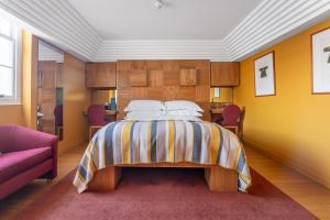 a bedroom with a bed and a pink couch at Drakes Hotel in Brighton & Hove