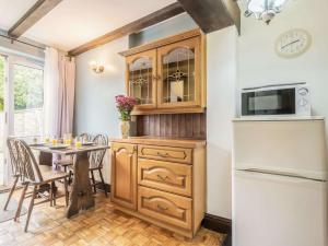 a kitchen with a wooden cabinet and a table at 2 Bed in Bacton 88326 in Bacton