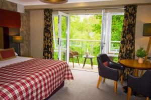 ein Hotelzimmer mit einem Bett und einem großen Fenster in der Unterkunft Craigmhor Lodge & Courtyard in Pitlochry
