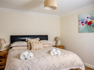 a bedroom with a bed with towels on it at 4 Bed in Ystradgynlais BN343 in Ystalyfera +15 photos