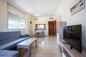 a living room with a couch and a flat screen tv at Residencial Playa de La Arena in Puerto de Santiago