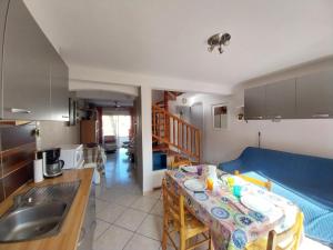 Una cocina y una sala de estar con una mesa y un sofá. en DUPLEX T3 Terrasse proche mer, en Narbonne-Plage 4 fotos más