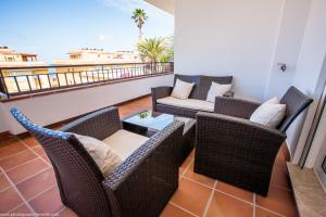 a balcony with wicker chairs and a table at Residencial Playa de La Arena in Puerto de Santiago