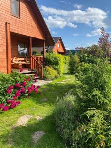 a house with a porch and flowers in the yard at Polna Przystań 694-272-463 in Uherce Mineralne (7)