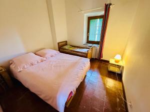 a small bedroom with a bed and a window at Maison accueillante à Laure-Minervois avec jardin in Laure-Minervois +4 photos