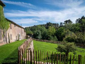 a wooden fence next to a building and a yard at Maison accueillante à Laure-Minervois avec jardin in Laure-Minervois