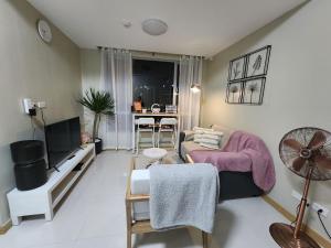 a living room with a couch and a table at Cozy 1BR Corner with Panoramic City Skyline View in Manila