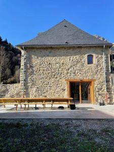 a stone building with a bench in front of it at Maison spacieuse à Guchen avec jardin et barbecue in Guchen