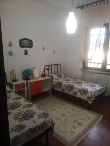 a room with two beds and a table and window at Villa Luisa in Carovigno