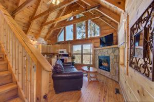 a living room with a staircase in a log cabin at The Vinson By Avada Properites in Gatlinburg
