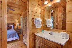 a log cabin bathroom with a sink and a bed at The Vinson By Avada Properites in Gatlinburg +27 photos