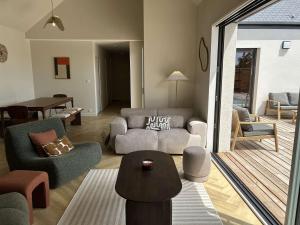 a living room with a couch and a table at 766 - Maison moderne avec piscine privative. in Erquy +18 photos