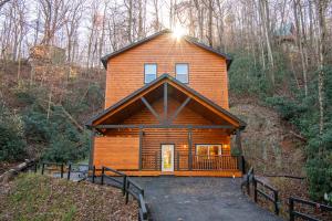 a large wooden cabin in the middle of a forest at Three Little Bears 2 By Avada Properties in Gatlinburg