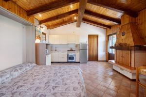 a kitchen with a bed in a room with wooden ceilings at Casa delle Delizie in SantʼAmbrogio di Valpolicella