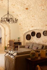 a living room with a couch and a stone wall at Masseria Tarsia Morisco in Polignano a Mare
