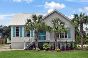 una casa con delle palme davanti di Coral Reef Cottage a Saint Simons Island