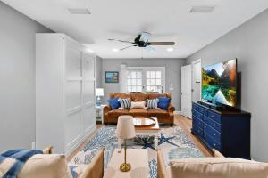 un soggiorno con un divano e una TV di Coral Reef Cottage a Saint Simons Island