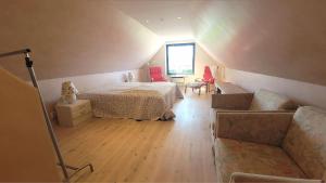 une chambre mansardée avec un lit et un canapé dans l'établissement Wallander's hometown, close to beach & café, à Ystad