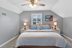 una camera da letto con un letto e un ventilatore a soffitto di Coral Reef Cottage a Saint Simons Island Altre 32 foto