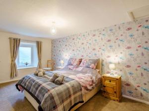 a bedroom with a bed with a flowery wallpaper at 3 bed in Threlkeld 86613 in Threlkeld
