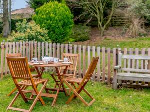 a wooden table with three chairs and a bench at 3 bed in Threlkeld 86613 in Threlkeld