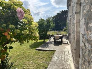 a patio with a table and chairs in a yard at 754 - Maison 3 chambres à 800m de la plage des Montiers in Erquy