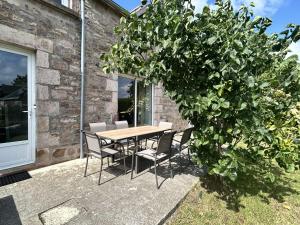 a table and chairs and a large tree on a patio at 754 - Maison 3 chambres à 800m de la plage des Montiers in Erquy