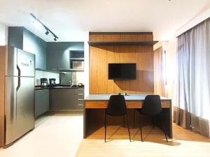 a kitchen with a counter with two chairs and a refrigerator at SouIcaraí by Housi in Niterói