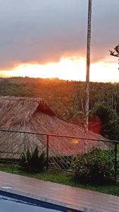 a house with a thatch roof and a fence at Rain view wayanad in Wayanad
