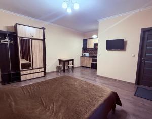 a bedroom with a bed and a table and a television at Modern Apartments in Mukacheve