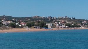 uma praia com uma cidade no topo de uma colina em Hotel Kleopatra em Stalos