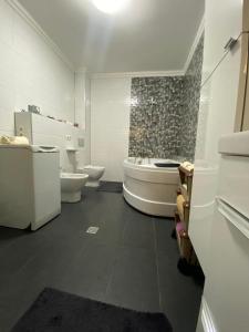 a bathroom with two sinks and a tub and two toilets at Andrada Holiday House in Oradea +10 photos