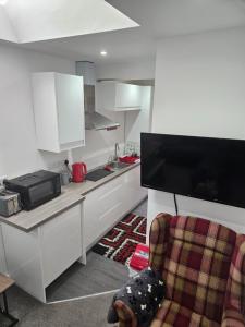 eine Küche mit weißen Schränken und einem Stuhl in einem Zimmer in der Unterkunft Cosy Corner - Town centre flat with free nearby parking in Shrewsbury + 67 Fotos