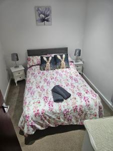 ein Schlafzimmer mit einem Bett mit geblümter Tagesdecke in der Unterkunft Cosy Corner - Town centre flat with free nearby parking in Shrewsbury